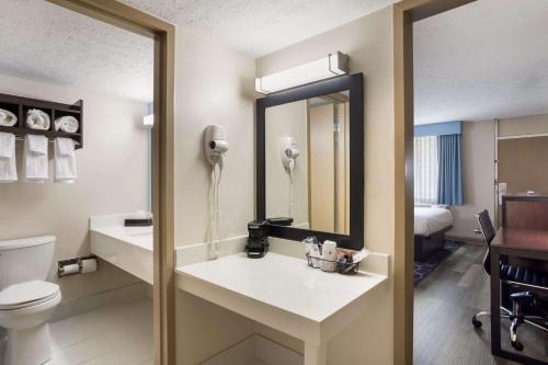 a bathroom with a toilet and a sink with a mirror at SureStay Hotel by Best Western Bardstown General Nelson in Bardstown