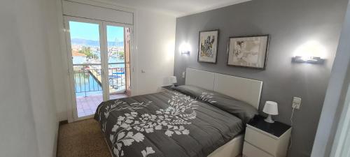 um quarto com uma cama e uma grande janela em Apartamento Bahia III em Empuriabrava