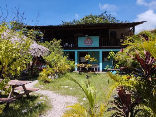 un edificio con una mesa de picnic en un jardín en Woodstock Hostel en Sámara