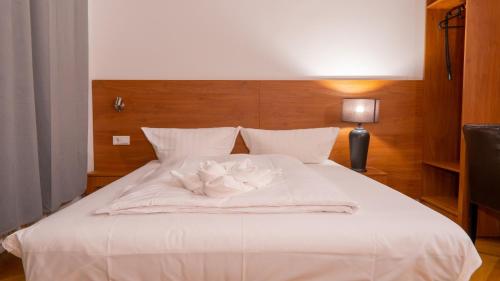 a white bed with two white flowers on it at Pension Majesty in Berlin
