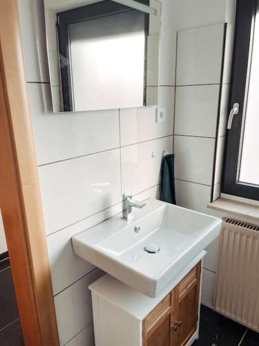 a bathroom with a white sink and a mirror at *TOP*+Allgäu*Familie*NETFLIX*mit Garten & *PS4* in Kaufbeuren