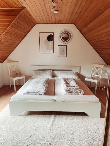 a large bed in a room with a wooden ceiling at *TOP*+Allgäu*Familie*NETFLIX*mit Garten & *PS4* in Kaufbeuren