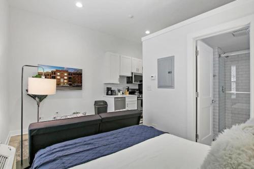 a white bedroom with a bed and a kitchen at Studio Apt with Laundry, Near Shops! - Montrose Studio rep in Chicago