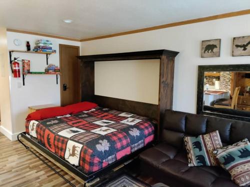 a bedroom with a bed and a leather couch at Alex's Cozy STUDIO with Pool and Sauna in Brian Head