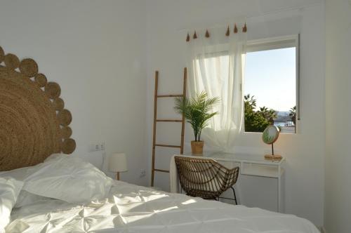 a bedroom with a bed and a desk and a window at Rosamar 211 Los Cristianos Ocean Views in Arona