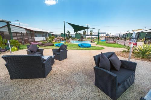 a group of chairs sitting on a patio with a playground at Darwin Resort in Darwin
