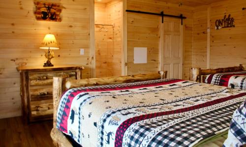 um quarto com 2 camas num chalé de madeira em The Sundowner on Lake George em Lake George