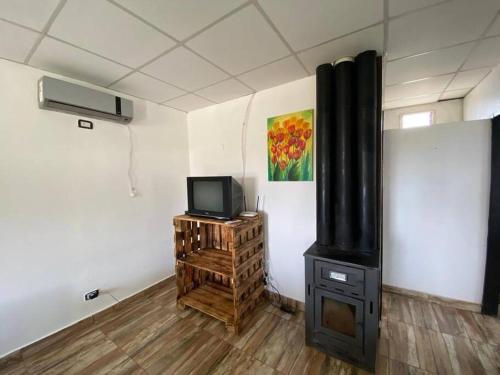 sala de estar con TV y fogones en Cabaña Merlot - Malbec en La Consulta