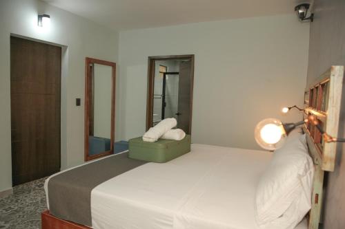a bedroom with a bed with a lamp and a mirror at Añoranza Hotel Boutique in Ciudad Hidalgo