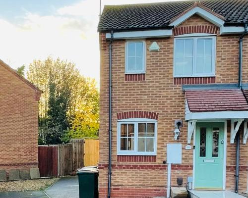 a brick house with a blue door on a street at Mezzo House- Entire property in Coventry