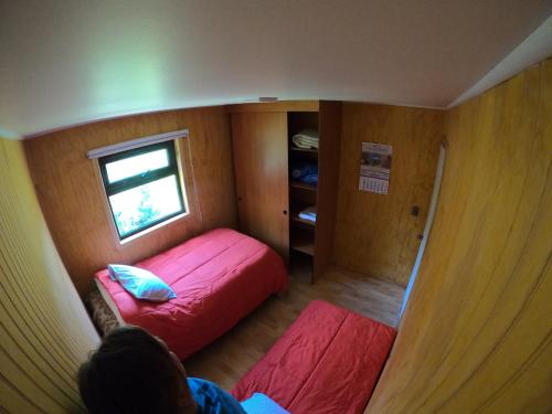 Habitación pequeña con 2 camas y ventana en Cabaña Nueva en Ancud Chiloe, en Ancud