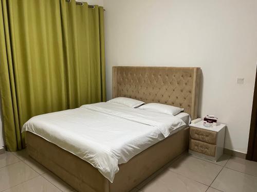 - une chambre avec un lit et un rideau vert dans l'établissement Wehome 忆江南民宿, à Dubaï
