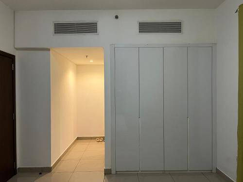 um armário com portas brancas num quarto em Wehome 忆江南民宿 em Dubai