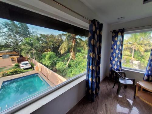 a room with a view of a swimming pool and a window at Le Grace Beachview in Chennai