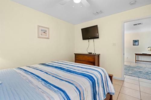a bedroom with a bed and a flat screen tv at Coastal Soul in Aransas Pass