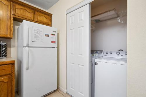 a kitchen with a white refrigerator and a washing machine at Coastal Soul in Aransas Pass