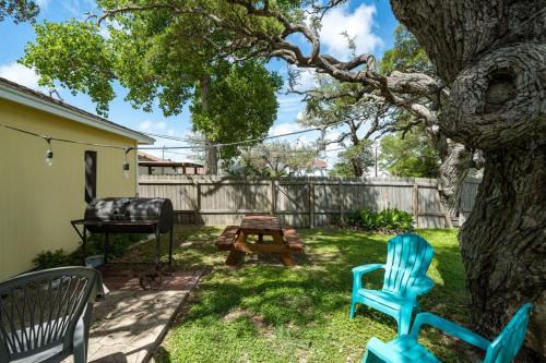 a yard with two chairs and a table and a tree at Coastal Soul in Aransas Pass