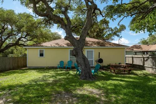 a house with chairs and a tree in the yard at Coastal Soul in Aransas Pass