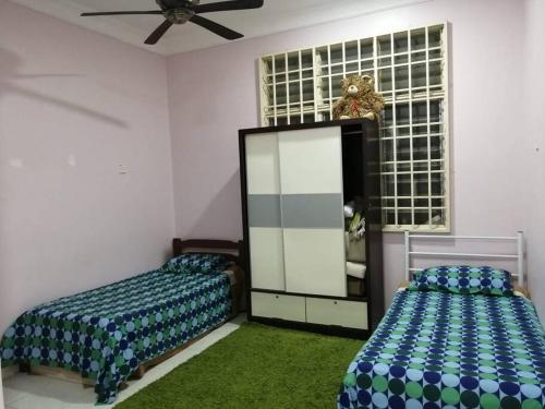 a bedroom with two beds and a window at SRI WANG HOMESTAY @ ARAU in Arau