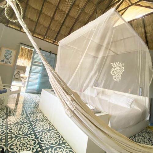 a hammock bed in a room with a wall at KokohauBungalows in Santa Verónica