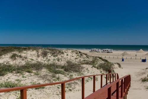 a sandy beach with a wooden path to the beach at On the Half Shell in Port Aransas