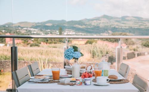 a white table with food and drinks on a balcony at Sao Vicente Lodge - Atlantic Retreat in São Vicente Ferreira