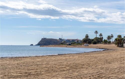 a sandy beach with palm trees and the ocean at Amazing Home In Puerto De Mazarrón in Puerto de Mazarrón