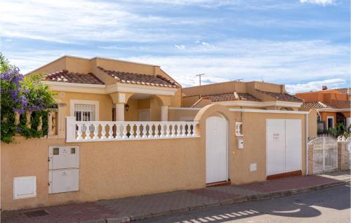 a house with two white doors and a fence at Amazing Home In Puerto De Mazarrón in Puerto de Mazarrón