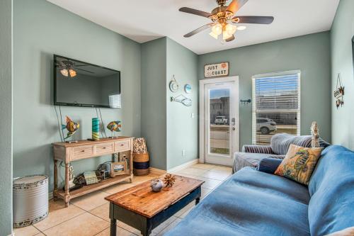 a living room with a blue couch and a tv at Sweet Retreat in Port Aransas