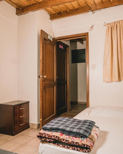 a bedroom with a bed and a wooden door at Wild Incas Hostel in Cuenca
