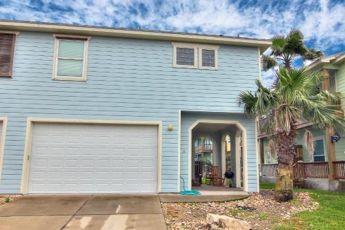 a blue house with a garage and a palm tree at Getaway in Port Aransas