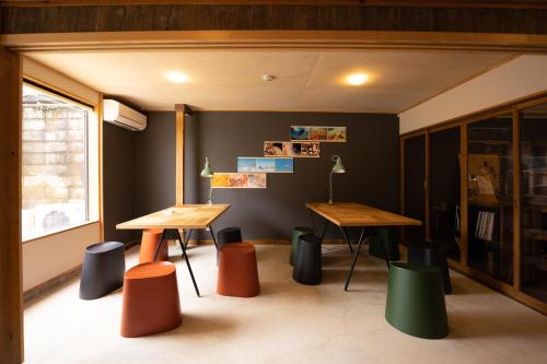 a room with two tables and chairs and a window at HOSTEL perch in Sado