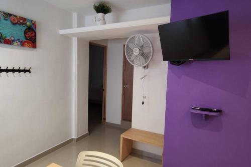 a living room with a fan and a purple wall at Morado Departamento 42 m2 CIVAC,NISSAN Y WALMART. in Jiutepec