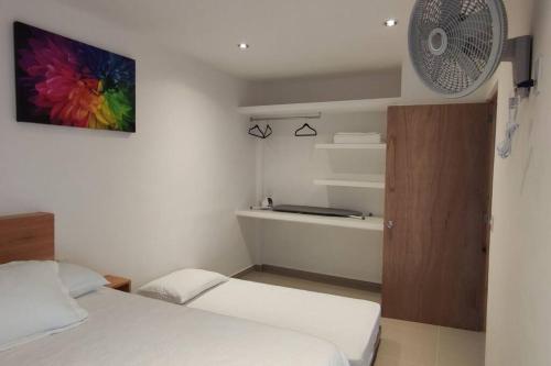 a small room with two beds and a fan at Morado Departamento 42 m2 CIVAC,NISSAN Y WALMART. in Jiutepec