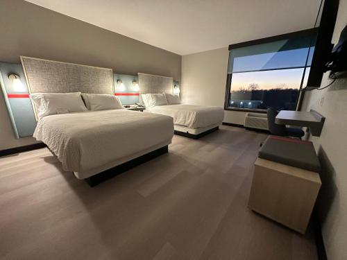 um quarto de hotel com duas camas e uma grande janela em AVID Hotels - Fort Wayne North, an IHG Hotel em Fort Wayne