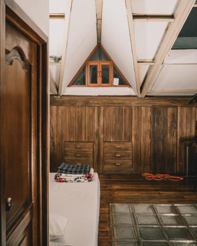 an attic room with a bed and a window at Wild Incas Hostel in Cuenca