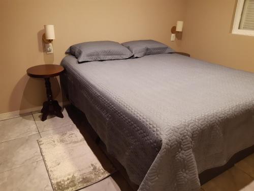 sypialnia z łóżkiem i małym stołem w obiekcie Rifugio del Camino - Chalé Completo w mieście Gramado