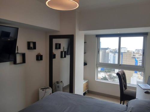ein Schlafzimmer mit einem Bett und einem großen Fenster in der Unterkunft Encantador apartamento en Miraflores in Lima