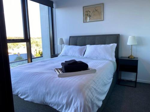 a bed with a tray with a bag on it at Central Canberra City apartment with study and full amenities including parking in Canberra