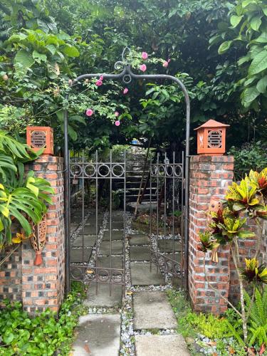 an entrance to a garden with a wrought iron gate at Blue Lagoon Cat Ba in Cat Ba