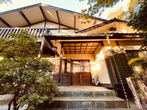 une maison avec un escalier menant à la porte d'entrée. dans l'établissement Secret Garden Resort&Onsen秘密の花園箱根温泉別荘, à Sengokuhara