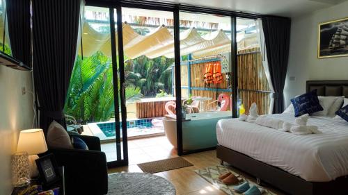 a bedroom with a bed and a view of a pool at Phetrapoolvilla (เภตราพูลวิลล่า) in Surat Thani