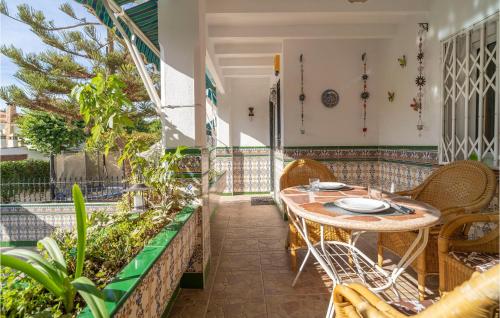 トレ・デル・マールにあるAmazing Home In Torre Del Mar With Wifiのバルコニーにテーブルと椅子が置かれたパティオ
