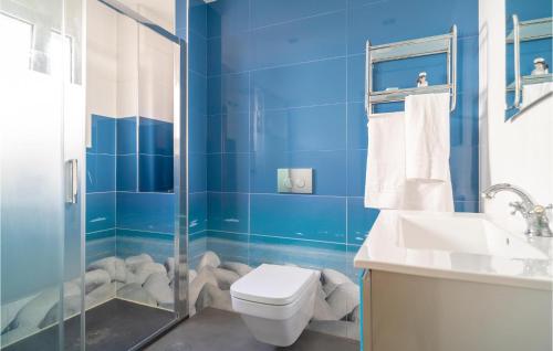 La salle de bains bleue est pourvue de toilettes et d'un lavabo. dans l'établissement 3 Bedroom Stunning Home In Torre Del Mar, à Torre del Mar