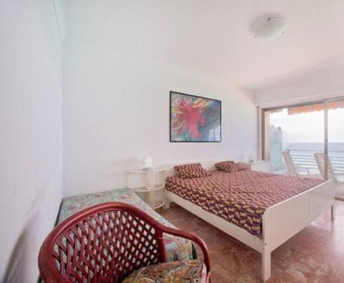 une chambre avec un lit, une chaise et une fenêtre dans l'établissement Flat Rossi, à Menton