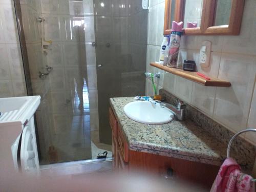 a bathroom with a sink and a shower and a sink at Torres a mais bela praia gaúcha in Torres