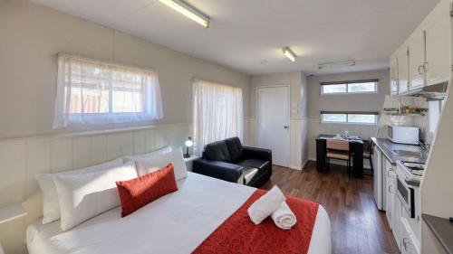 a living room with a large bed and a kitchen at Yarrawonga Riverlands Tourist Park in Yarrawonga