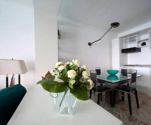 un vase de fleurs sur une table dans le salon dans l'établissement Flat Rossi, à Menton