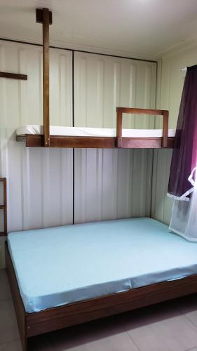 two bunk beds in a room with a blue mattress at Apt 2 quartos, 5 pessoas em Container House in São Francisco do Sul