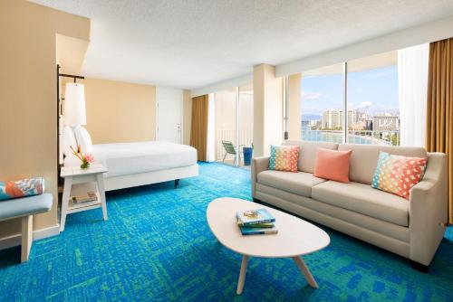 a hotel room with a couch and a bed at The Twin Fin Hotel in Honolulu